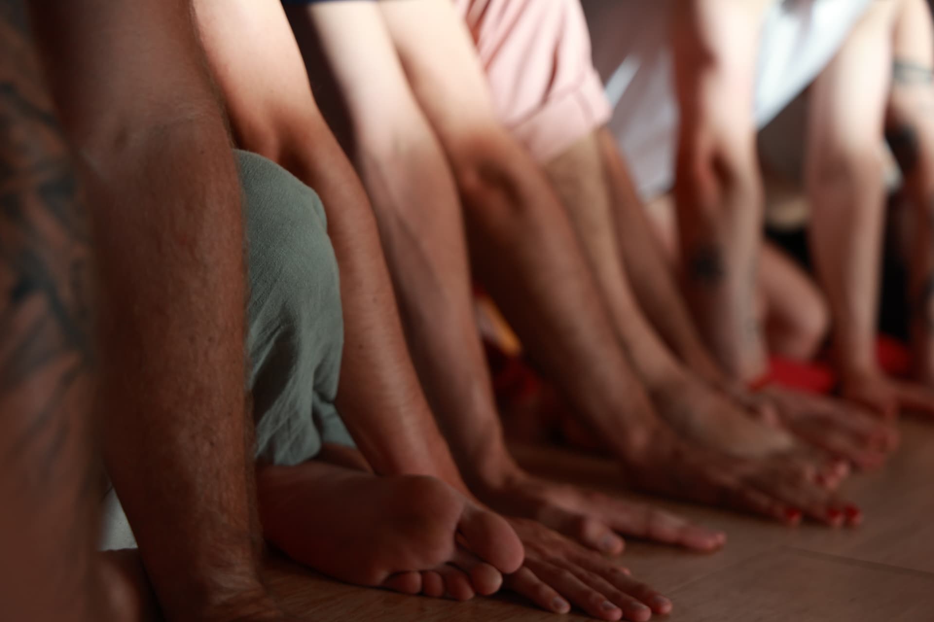 Groupe assis en cercle, mains posées au sol